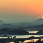 Sunset over Jawai hills and dam with calm lake view