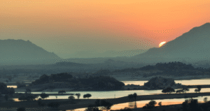 Sunset over Jawai hills and dam with calm lake view
